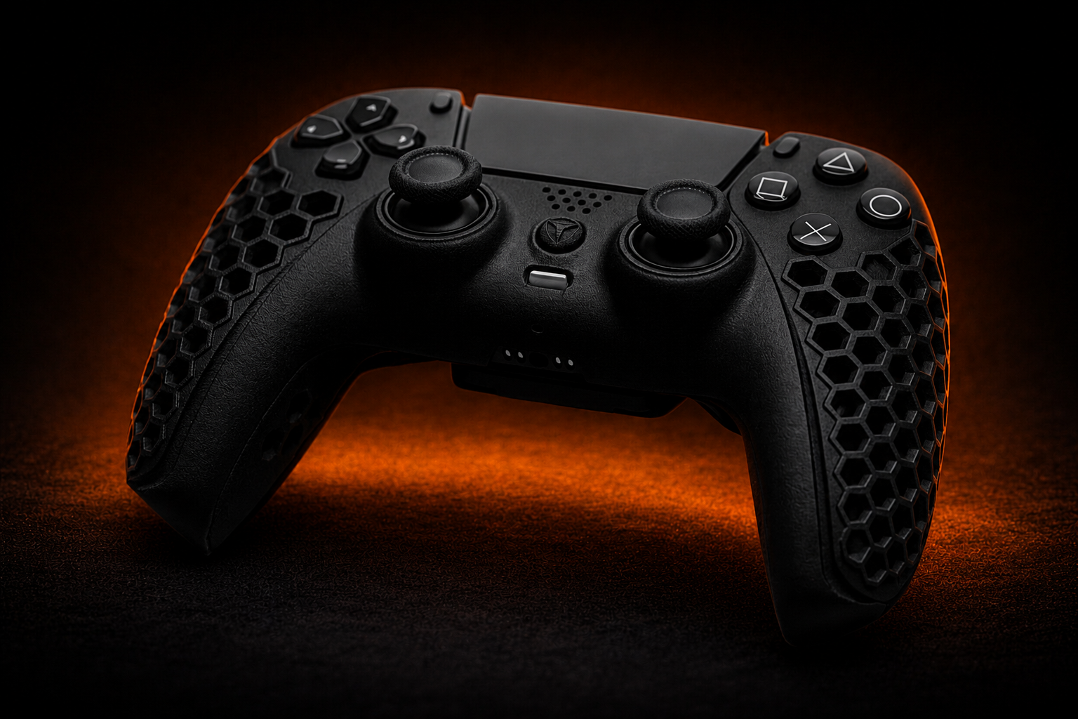Black gaming controller with textured grips on a dark background