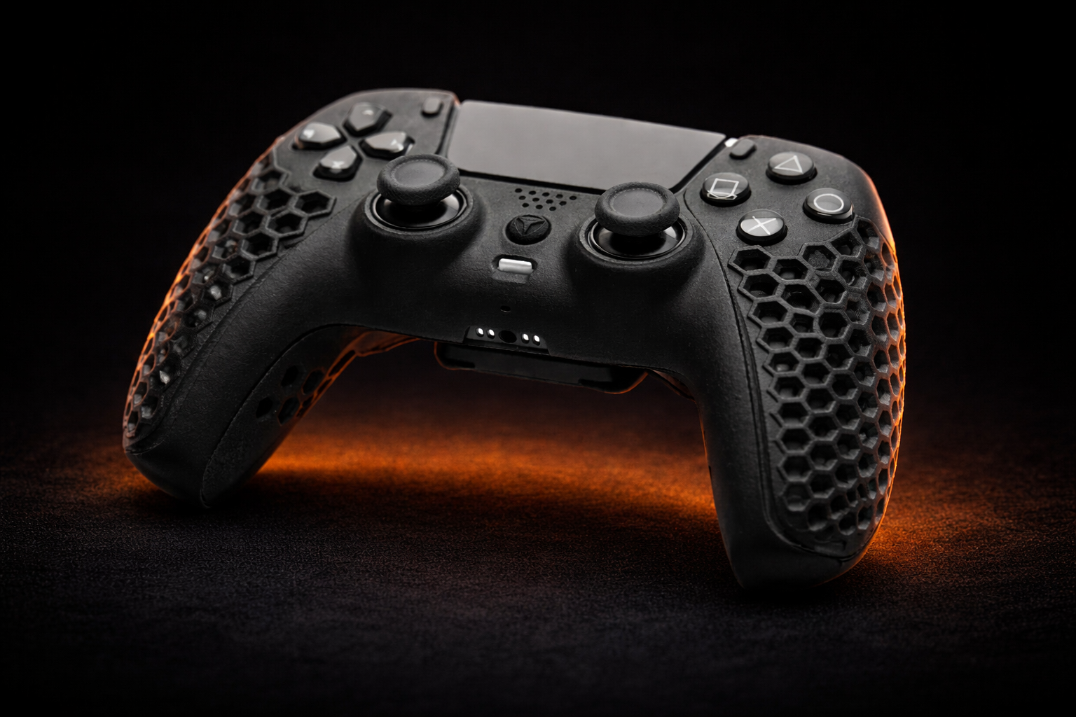 Low angle close-up of the black Helico HexaVent custom PS5 and PC controller. The atmospheric lighting highlights the TMR drift-free analog sticks, tactile mechanical face buttons, and signature honeycomb ventilated grips.
